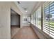 Bright sunroom featuring shuttered windows, ceiling fan, and wood look tiled floors at 1903 Canterbury Ln # B24, Sun City Center, FL 33573