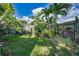 A private backyard oasis featuring lush landscaping, tropical plants, and a wood privacy fence at 2559 Redwood Cir, Clearwater, FL 33763
