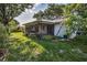 The lush backyard features a screened lanai, mature trees, and well-maintained landscaping at 2559 Redwood Cir, Clearwater, FL 33763