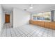 A bedroom with white tile floors, large window, built-in drawers, and ceiling fan at 2559 Redwood Cir, Clearwater, FL 33763
