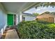View of the home's entrance featuring a bright green front door and lush landscaping at 2559 Redwood Cir, Clearwater, FL 33763