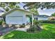 Well-maintained single-story home with attached garage, green front door and manicured landscaping at 2559 Redwood Cir, Clearwater, FL 33763