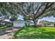 Traditional one story home with an attached garage and a beautiful shady tree at 2559 Redwood Cir, Clearwater, FL 33763