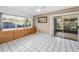 Bright living room with white tile floors, large window, built-in drawers, and sliding glass doors to screened lanai at 2559 Redwood Cir, Clearwater, FL 33763