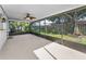 A screened patio with a ceiling fan provides a view of the backyard and lush landscaping at 2559 Redwood Cir, Clearwater, FL 33763