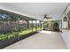 A screened patio with a ceiling fan overlooks the backyard and garden, offering a tranquil space at 2559 Redwood Cir, Clearwater, FL 33763