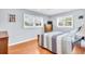 Bedroom with hardwood floors, two windows with plantation shutters, dresser, and wooden furniture at 2814 Highlands Blvd # B, Palm Harbor, FL 34684