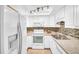 Bright kitchen with white cabinetry, mosaic tile backsplash, stainless steel sink, and modern appliances at 2814 Highlands Blvd # B, Palm Harbor, FL 34684