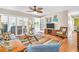Living room with hardwood floors, neutral paint, and a ceiling fan that blends indoor-outdoor living at 2814 Highlands Blvd # B, Palm Harbor, FL 34684