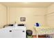 Bright laundry room with two machines, a folding table, and storage at 2900 45Th S St # 26, Gulfport, FL 33711
