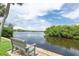 Scenic waterfront view with a tranquil bench, lush greenery, and calm water, offering a serene outdoor experience at 2900 45Th S St # 26, Gulfport, FL 33711