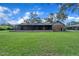 View of backyard featuring a covered patio and a large green lawn at 302 Old Mulrennan Rd, Valrico, FL 33594