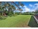 Large backyard with green grass and a wooden shed at 302 Old Mulrennan Rd, Valrico, FL 33594