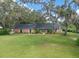 Sprawling single-story brick home with expansive front lawn and mature shade trees at 302 Old Mulrennan Rd, Valrico, FL 33594