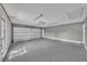 Spacious garage with speckled epoxy floors, white door, and overhead lighting at 302 Old Mulrennan Rd, Valrico, FL 33594