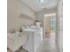 Bright laundry room with white appliances and tiled floors at 302 Old Mulrennan Rd, Valrico, FL 33594