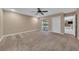 Spacious main bedroom with neutral carpet, ceiling fan, and sliding doors to lanai at 302 Old Mulrennan Rd, Valrico, FL 33594