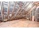 Spacious unfinished attic with insulation, wooden beams, and wood flooring at 3125 S Miller Rd, Valrico, FL 33596