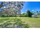 Large backyard with lush green grass, mature trees, and a storage shed at 3125 S Miller Rd, Valrico, FL 33596