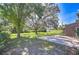 Expansive backyard featuring a brick patio, mature trees, and ample green space at 3125 S Miller Rd, Valrico, FL 33596