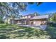 Home exterior with a brick patio, manicured lawn and mature trees at 3125 S Miller Rd, Valrico, FL 33596