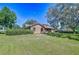 Home exterior featuring a well-maintained lawn, mature trees, and brick accents at 3125 S Miller Rd, Valrico, FL 33596