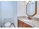 Cozy half bath with granite countertop vanity and decorative mirror at 3125 S Miller Rd, Valrico, FL 33596