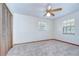 Bedroom featuring a ceiling fan, plush carpet, closet and natural light at 3125 S Miller Rd, Valrico, FL 33596