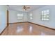 Bright bedroom with hardwood floors, ceiling fan, and multiple windows at 3125 S Miller Rd, Valrico, FL 33596