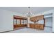 Open dining room with chandelier lighting and kitchen bar with stools at 3125 S Miller Rd, Valrico, FL 33596