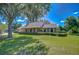 Lovely single-story brick home featuring a lush front lawn, mature trees, and an attached two-car garage at 3125 S Miller Rd, Valrico, FL 33596