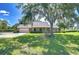 Charming single-story home with a well-manicured lawn, mature trees, and a two-car garage at 3125 S Miller Rd, Valrico, FL 33596