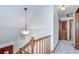 Hallway with wooden railing and a decorative light fixture at 3125 S Miller Rd, Valrico, FL 33596