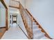 Carpeted staircase with wood banister in a spacious entryway with tile flooring at 3125 S Miller Rd, Valrico, FL 33596