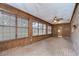Cozy sunroom with wood paneling, large windows, and brick-look floors at 3125 S Miller Rd, Valrico, FL 33596
