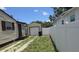 View of a detached garage in the backyard with a white fence separating the properties at 3131 Melton N St, St Petersburg, FL 33704