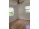 Inviting bedroom featuring laminate wood flooring, natural light through two windows, and a ceiling fan at 3131 Melton N St, St Petersburg, FL 33704