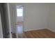 Comfortable room featuring laminate wood flooring and white walls; view of the next room through open door at 3131 Melton N St, St Petersburg, FL 33704