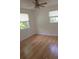 Inviting bedroom featuring laminate wood flooring, natural light through two windows, and a ceiling fan at 3131 Melton N St, St Petersburg, FL 33704