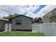 View of the detached garage in the backyard and white fence separating the properties at 3131 Melton N St, St Petersburg, FL 33704