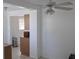 Open layout with access to kitchen featuring white walls and a ceiling fan; view of the eat-in kitchen at 3131 Melton N St, St Petersburg, FL 33704