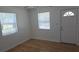 Bright living room featuring laminate wood flooring, natural light through a window and door, and a ceiling fan at 3131 Melton N St, St Petersburg, FL 33704