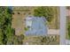 Bird's-eye view of property with covered patio, lawn, driveway, and surrounding greenery at 3144 Abeline Rd, Spring Hill, FL 34608