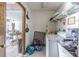 Bright laundry room featuring tile floors, utility sink, washer, and upper shelf storage at 3144 Abeline Rd, Spring Hill, FL 34608