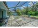 Outdoor pool surrounded by greenery and covered by netting at 3144 Abeline Rd, Spring Hill, FL 34608