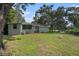 Exterior shot of backyard with large mature trees and a fire pit for entertaining at 3205 68Th N Ave, St Petersburg, FL 33702