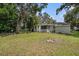 Spacious backyard featuring lush lawn and a fire pit perfect for outdoor gatherings by the screened-in porch at 3205 68Th N Ave, St Petersburg, FL 33702
