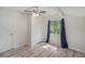 Well-lit bedroom with wood-look floors, a ceiling fan, and a window overlooking the backyard at 3205 68Th N Ave, St Petersburg, FL 33702