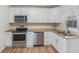 Updated kitchen featuring granite countertops, white cabinets, and stainless steel appliances at 3205 68Th N Ave, St Petersburg, FL 33702