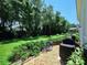 Well-maintained backyard with a stone path, black patio furniture, and mature trees at 3506 Cordgrass Dr, Valrico, FL 33596